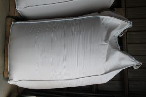 White fabric cover for a large outdoor furniture piece or equipment.