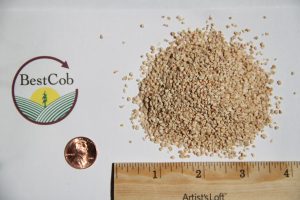 Close-up of beige granular product with Best Cob logo and ruler for scale.