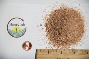 Close-up of ground coffee with Best Cob logo and ruler for scale.
