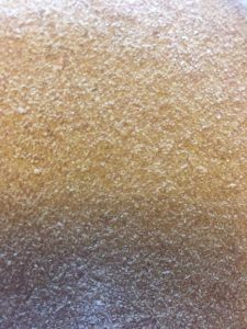 Close-up of a textured cob surface with a mix of beige and gray tones.