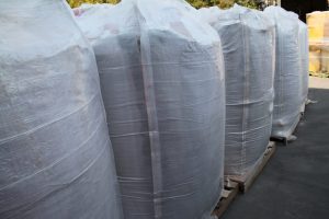 Large white bags filled with construction or industrial materials on pallets.
