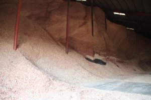 Large pile of gravel or crushed stone stored in an industrial warehouse.
