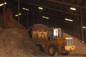 Heavy machinery at Best Cob facility processing organic materials for soil enhancement.
