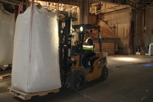 Employee transporting cobs using a forklift