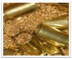 Close-up of gold-colored metal cups and small copper granules for cobblestone making.