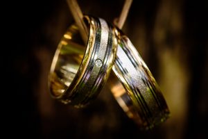 Close-up of wedding rings hanging with a blurred background.