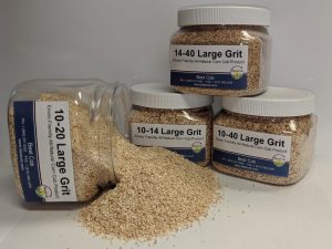 Assorted sizes of Best Cob large grit corn cob products in jars and spilled on surface.