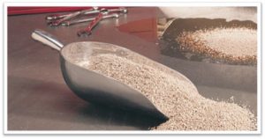 Close-up of a scoop filled with textured construction aggregate material.