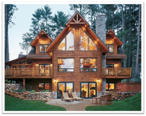 Beautiful wooden cabin in a forest with large windows and outdoor seating area.