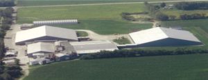 Aerial view of Best Cob building complex surrounded by green fields.