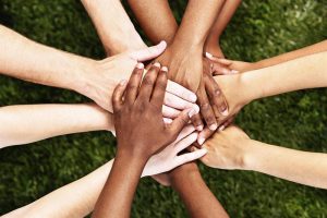 Diverse hands stacked together symbolizing unity and teamwork.