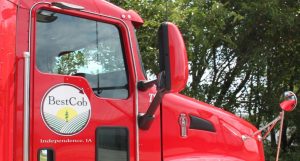 Red Best Cob truck with logo and trees in background for Independence, IA.
