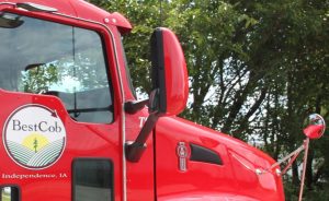 Close-up of a red Best Cob truck with logo and side mirror in Independence, Iowa.