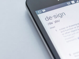 Close-up of a tablet displaying the word 'design' with its definition on a white background.