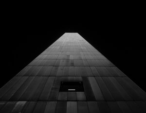 Modern skyscraper viewed from below against a black sky.